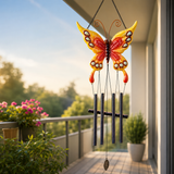 Butterfly-shaped wind chime on a balcony with plants and flowers in the background